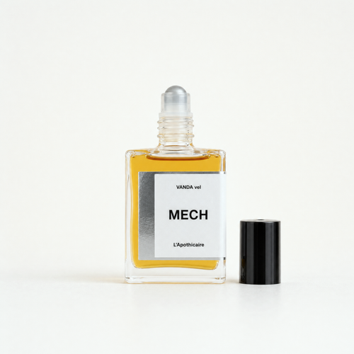 A clear glass roller bottle filled with amber-yellow liquid, featuring a white label with black text that reads 'VANDA vel MECH L'Apothicaire'. The silver roller ball cap is shown detached and standing next to the bottle on a clean, light beige background.
