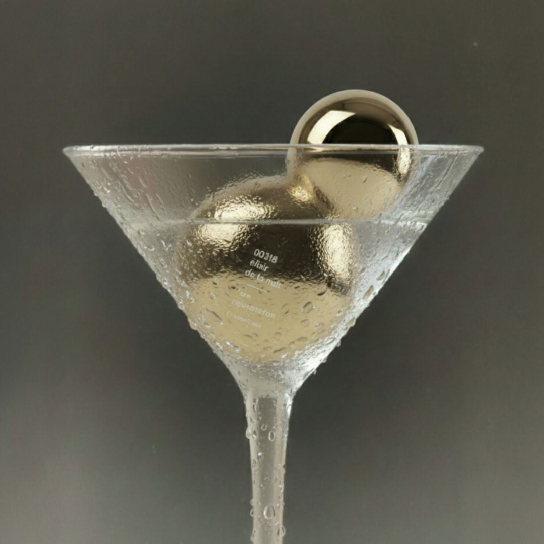 Martini glass with a gold perfume bottle e on a dark background
